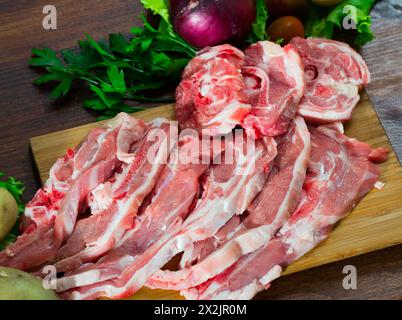 Assortiment d'agneau et de légumes crus sur un bureau en bois naturel Banque D'Images