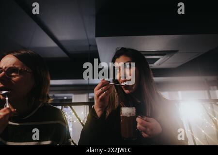 Amis appréciant une soirée décontractée avec des boissons dans un bar d'ambiance confortable. Banque D'Images