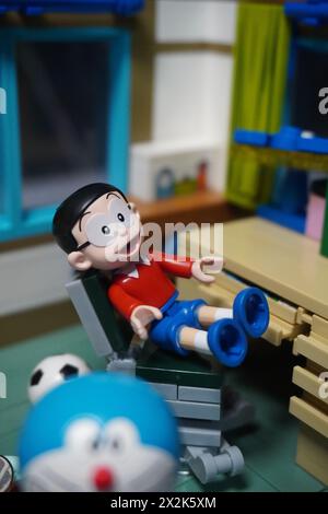 Figurine jouet Nobita assise sur une chaise près de la table d'étude avec Doraemon Banque D'Images