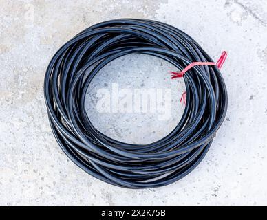 Une bobine de câble d'alimentation en cuivre sur fond de béton Banque D'Images