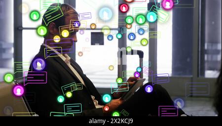 Image des icônes de profil et de message sur l'homme d'affaires caucasien utilisant la tablette numérique à un aéroport Banque D'Images