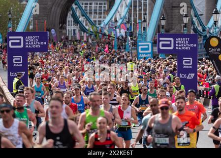 Des masses de coureurs participant au TCS London Marathon 2024 passant par Tower Hill, Londres, Royaume-Uni. Après avoir traversé Tower Bridge Banque D'Images