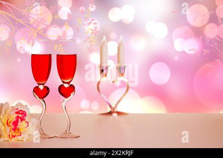 Modèle Happy Valentines ou Mothers Day. Composition décorative de verres de champagner, fleurs, bougies sur table sur fond de printemps abstrait. Banque D'Images