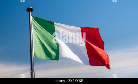 Die Fahne von Italien flattert im Wind, isoliert gegen blauer Himmel Banque D'Images