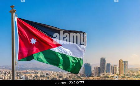 Die Fahne von Jordanien flattert im Wind, isoliert gegen blauer Himmel Banque D'Images