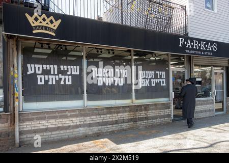 L'extérieur de Farkas Judaica à Williamsburg avec de grands signes yiddish dans leurs fenêtres sur le nettoyage des châles de prière. Sur Rodney Street, 2024. Banque D'Images