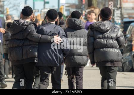 AMITIÉ. 4 garçons juifs orthodoxes portant des yarmulkes noirs marchent ensemble sur Lee Avenue à Williamsburg, Brooklyn, New York. Banque D'Images