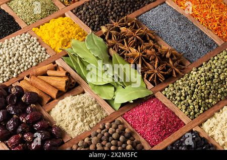 Épices et herbes colorées dans des plateaux en bois. Fond d'assaisonnement pour la conception d'emballage avec de la nourriture. Banque D'Images