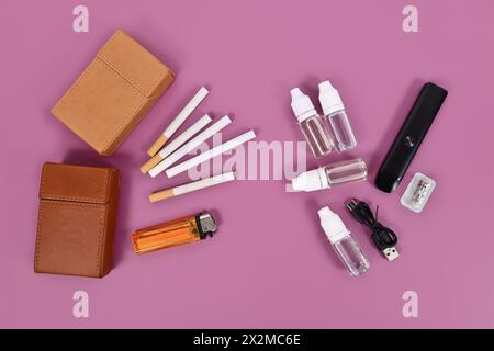 Comparaison entre cigarette électronique et vraie avec des outils sur fond violet Banque D'Images