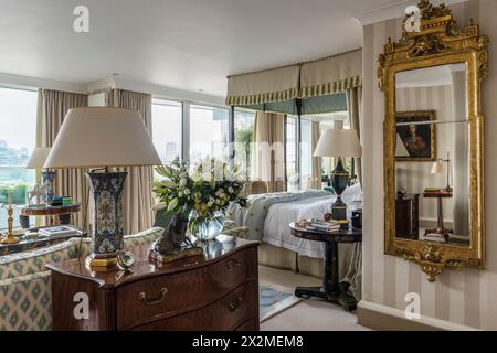 Miroir encadré doré avec lampe sur commode dans l'appartement Chelsea, Londres Royaume-Uni Banque D'Images