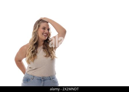Jeune femme caucasienne grande taille rit, la main sur la tête, regardant latéralement sur le blanc, copiez l'espace Banque D'Images