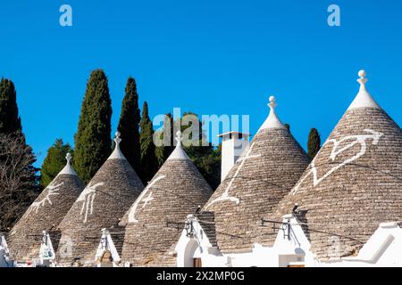 Symboles blanchis à la chaux sur le toit en pierre rénové d'un trullo, Alberobello, Italie Banque D'Images