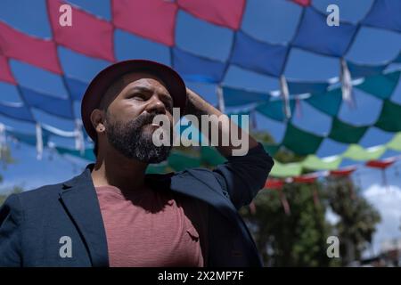 Portrait d'homme bohème d'Amérique latine avec barbe, chapeau et veste. Fond de drapeaux colorés. Concept de vraies personnes. Banque D'Images
