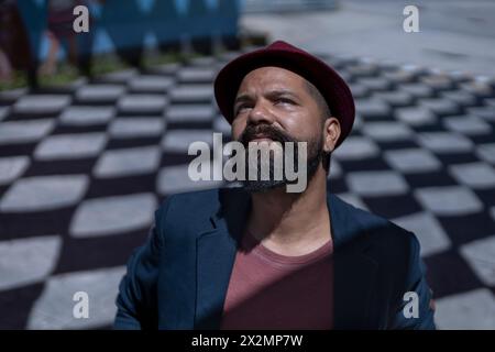 Portrait d'homme bohème d'Amérique latine avec barbe, chapeau et veste. Fond d'ombres avec des formes de losange. Concept de vraies personnes. Banque D'Images