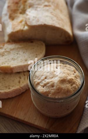 Levain au levain dans un bocal en verre et pain sur la table Banque D'Images