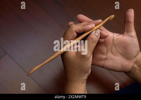 Gros plan des mains d'une femme tenant une aiguille au crochet en bambou. Concept de loisirs et de temps libre Banque D'Images