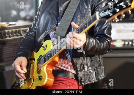 Jeune homme joue de la guitare électrique en studio Banque D'Images