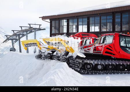 Deux machines rouges pour la préparation des pistes de ski dans les Alpes autrichiennes. Banque D'Images