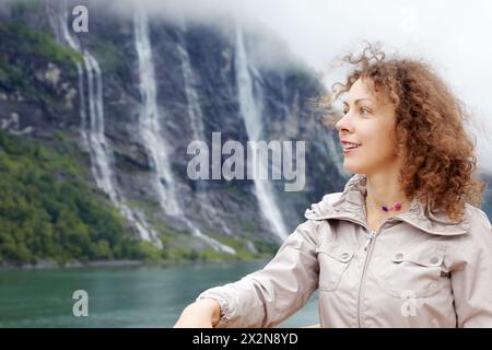 Portrait de femme contre la cascade de sept Sœurs dans le fjord de Geiranger, Norvège. Banque D'Images