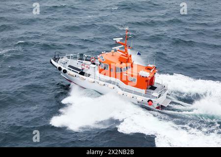 Bateau blanc flotte dans la mer, mousse blanche et vaporiser sur l'eau bleu foncé Banque D'Images