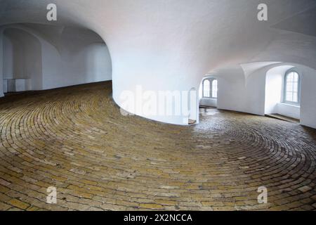 Montée de la vis dans la tour Rundetarn à Copenhague, Danemark. Plancher de briques et murs blancs Banque D'Images