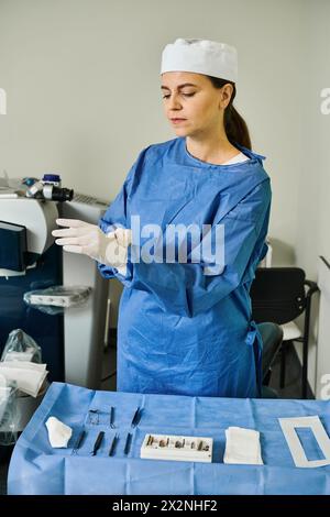 Une femme dans une robe de chirurgie se tient à côté d'une table dans un cadre médical. Banque D'Images