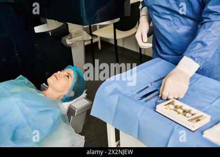 Une femme dans une robe bleue se détend sur un lit d'hôpital. Banque D'Images