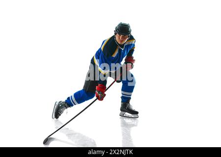 Joueur de hockey professionnel concentré avec bâton montrant le contrôle de palet sur fond blanc de studio. Banque D'Images