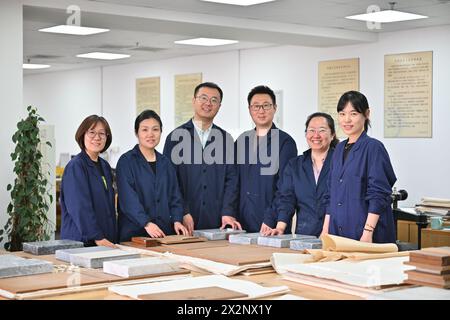 (240423) -- TIANJIN, 23 avril 2024 (Xinhua) -- Gao Xuemiao (3e l) pose pour une photo de groupe avec ses collègues à la bibliothèque de Tianjin dans la municipalité de Tianjin, dans le nord de la Chine, le 22 avril 2024. La bibliothèque de Tianjin abrite une collection de 590 000 livres anciens et a mené des travaux de restauration de livres anciens pendant plus de 70 ans. Gao Xuemiao, 38 ans, dirige l’équipe de restauration de la bibliothèque. Il est le premier expert en restauration ayant une formation en chimie depuis la création du département en 1978. De nos jours, la restauration de livres anciens est de plus en plus considérée comme un processus interdisciplinaire. L'incor Banque D'Images