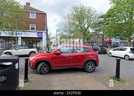 Une voiture mal garée obstruant un trottoir tombé sur un trottoir dans une grande rue de banlieue, Shepperton Surrey Angleterre Banque D'Images