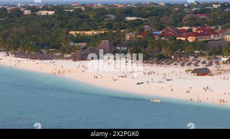 Plage de Kendwa avec beaucoup de monde et un bateau dans l'eau. La scène est détendue et amusante, concept d'été, Tanzanie, Zanzibar Banque D'Images