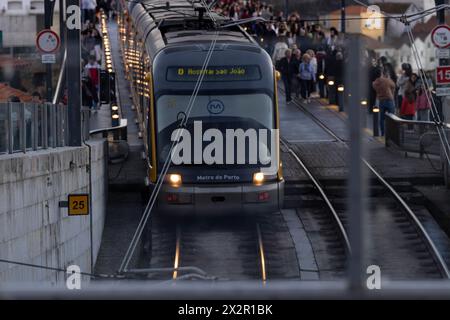 Porto, Portugal - 02.2024 : métro de Porto - ligne d - Hôpital Sao Joao passant sur le pont d Luiz I au coucher du soleil plein de touristes. Ville de Porto en po Banque D'Images