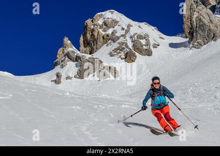 Femme arrière ski de fond descente sur Gruensteinscharte à Grunstein, Mieming Range, Tyrol, Autriche Banque D'Images