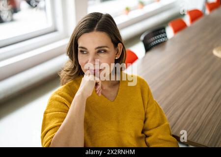 Femme d'affaires créative réfléchie assise dans le bureau Banque D'Images