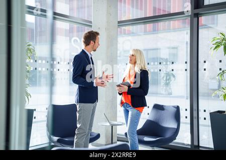 Businessman discuter avec businesswoman in office Banque D'Images