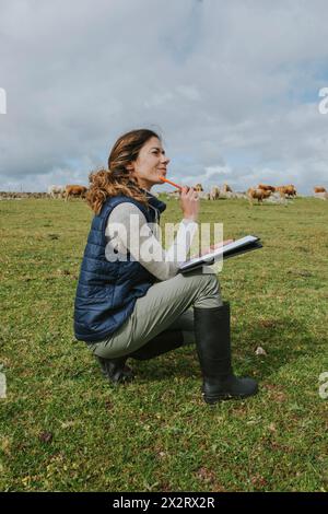 Vétérinaire réfléchi accroupi à la ferme Banque D'Images