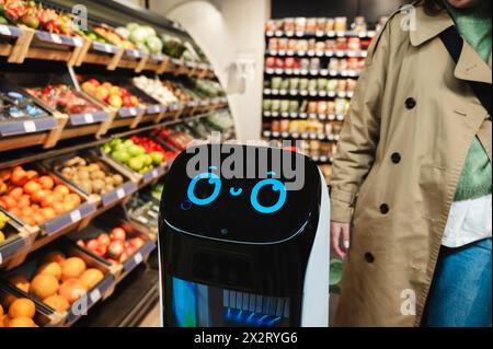 Assistant robot intelligent près de la femme à l'épicerie Banque D'Images