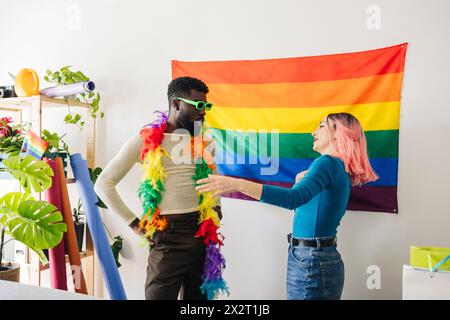 Femme parlant avec un ami non binaire essayant le boa à plumes à la maison Banque D'Images