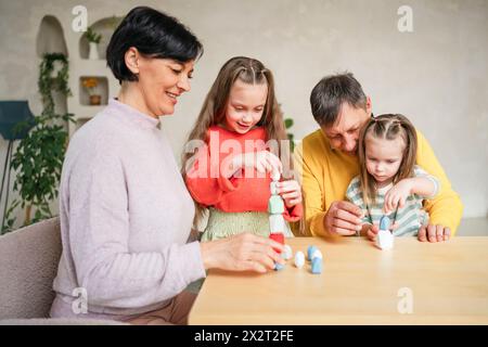 Heureux grands-parents jouant au jeu avec les petits-enfants sur la table à la maison Banque D'Images