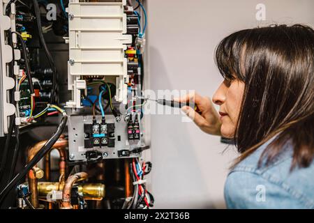 Technicien féminin spécialisé réparant l'unité de climatisation Banque D'Images