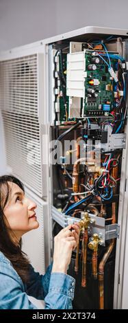 Technicien du climatiseur qui effectue l'entretien de l'unité de climatisation Banque D'Images