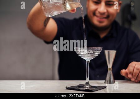 Bartender pouring cocktail au comptoir de bar en verre Banque D'Images