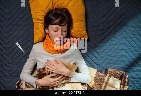 Femme malade dormir sur le lit chez lui Banque D'Images