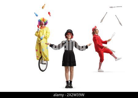 Magicien féminin debout devant un clown et jongleur isolé sur fond blanc Banque D'Images