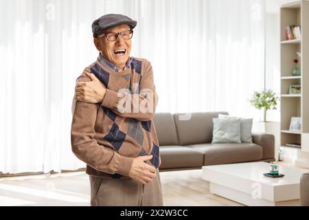 Homme âgé à domicile souffrant de douleurs sévères à l'épaule Banque D'Images