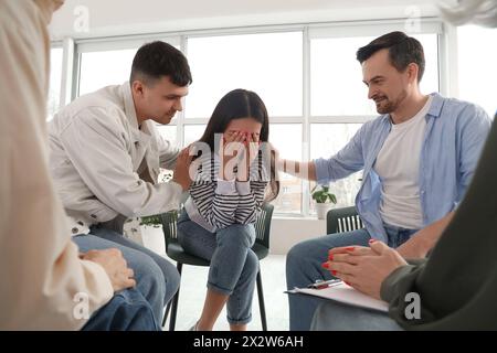 Une jeune femme bouleversée pleure lors d'une séance de thérapie de groupe Banque D'Images