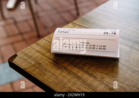 Madrid, Espagne. 1er avril 2024 le reçu total du chèque pour 39,70 euros se trouve sur une table en bois dans un bar, restaurant. Paiement pour le déjeuner dîner dans un café espagnol Banque D'Images