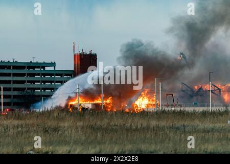 Edmonton, Canada. 22 avril 2024. L'avant d'un hangar s'effondre lors d'un incendie de 5 alarmes qui a détruit un hangar aérien historique de la seconde Guerre mondiale à Edmonton. Le hangar qui a été construit en 1942 a été déclaré un bâtiment historique d'importance pour sa part dans l'expédition d'équipements, de troupes et d'avions pour les forces américaines en route vers la Russie. La cause de l'incendie fait actuellement l'objet d'une enquête et aucun mot n'est encore dit concernant les dommages estimés. Crédit : SOPA images Limited/Alamy Live News Banque D'Images