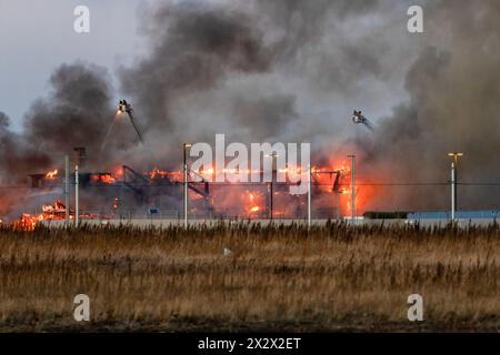 Edmonton, Canada. 22 avril 2024. Un incendie de 5 alarmes détruit un hangar aérien historique de la seconde Guerre mondiale alors que le service d'incendie d'Edmonton protège le site de la propagation à d'autres bâtiments. Le hangar qui a été construit en 1942 a été déclaré un bâtiment historique d'importance pour sa part dans l'expédition d'équipements, de troupes et d'avions pour les forces américaines en route vers la Russie. La cause de l'incendie fait actuellement l'objet d'une enquête et aucun mot n'est encore dit concernant les dommages estimés. Crédit : SOPA images Limited/Alamy Live News Banque D'Images