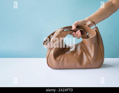 Femme tenant un sac en cuir marron. Copier l'espace. Banque D'Images